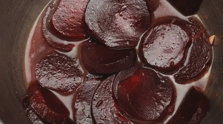 Rodelas de beterraba cozidas em uma panela de inox, vistas de cima